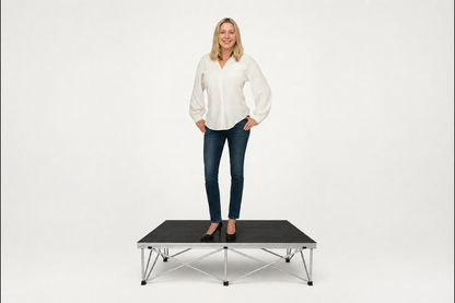 Woman standing on LimeLight portable stage platform and riser combination, 8 inches high, with black HexCoat finish.
