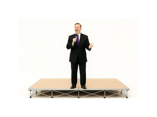 Man in a suit standing on a LimeLight Lite Series 8x8 modular stage platform in Wood Laminate at 8" height. Ideal for schools, churches, and event professionals.