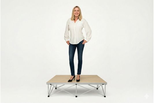 Woman standing on a LimeLight Lite Series 4x4 stage riser in Grey Carpet at 8" height. Ideal for schools, churches, and event professionals.