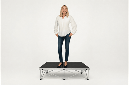 Woman standing on LimeLight portable stage platform and riser combination, 8 inches high, with black HexCoat finish.